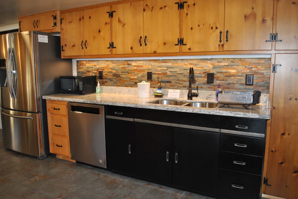 Kitchen features a deep sink with spray handle and dishwasher for long-term stay convenience. Notice the pine cabinets which were added in the 50s.